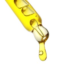 Photo of Dripping yellow facial serum from pipette on white background, closeup