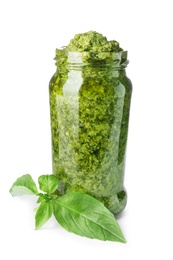 Jar of tasty pesto sauce and basil leaves isolated on white