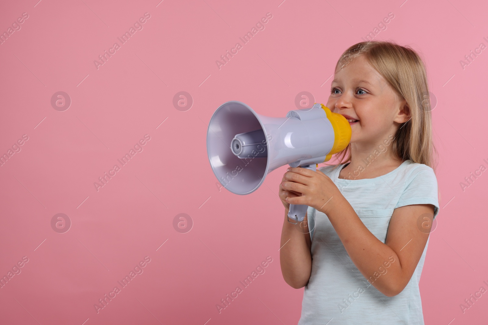 Photo of Special promotion. Little girl with megaphone on pink background. Space for text