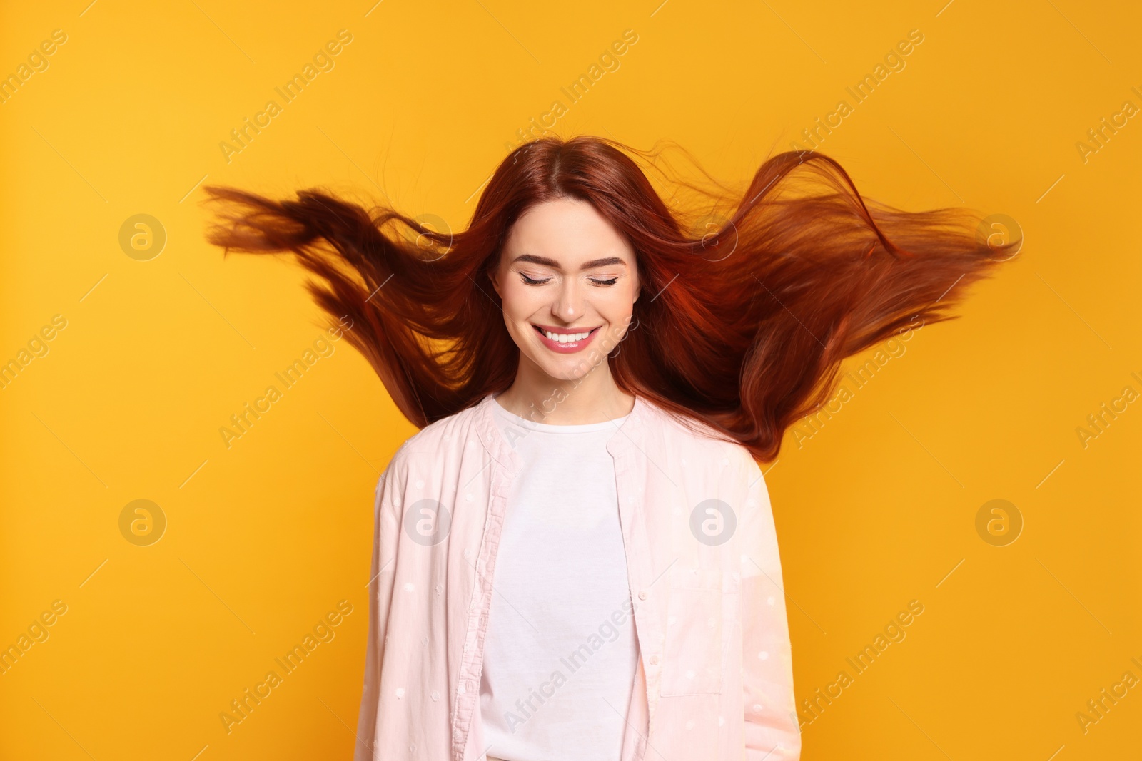 Photo of Happy woman with red dyed hair on orange background