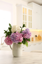 Photo of Bouquet with beautiful hydrangea flowers on white marble table