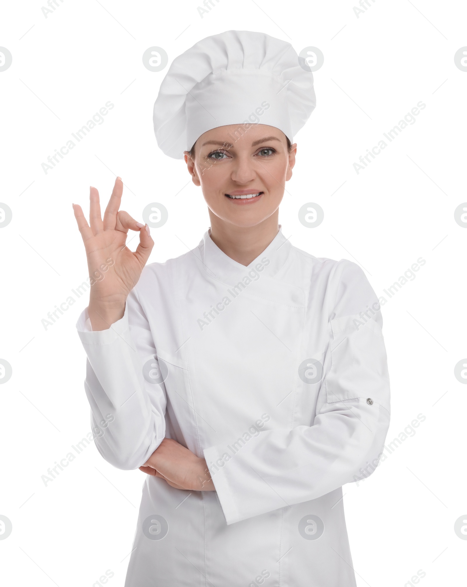 Photo of Happy woman chef in uniform showing OK gesture on white background