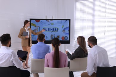 Photo of Business trainer using interactive board in meeting room during presentation
