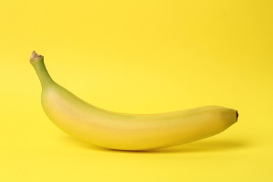 Photo of One ripe sweet banana on yellow background