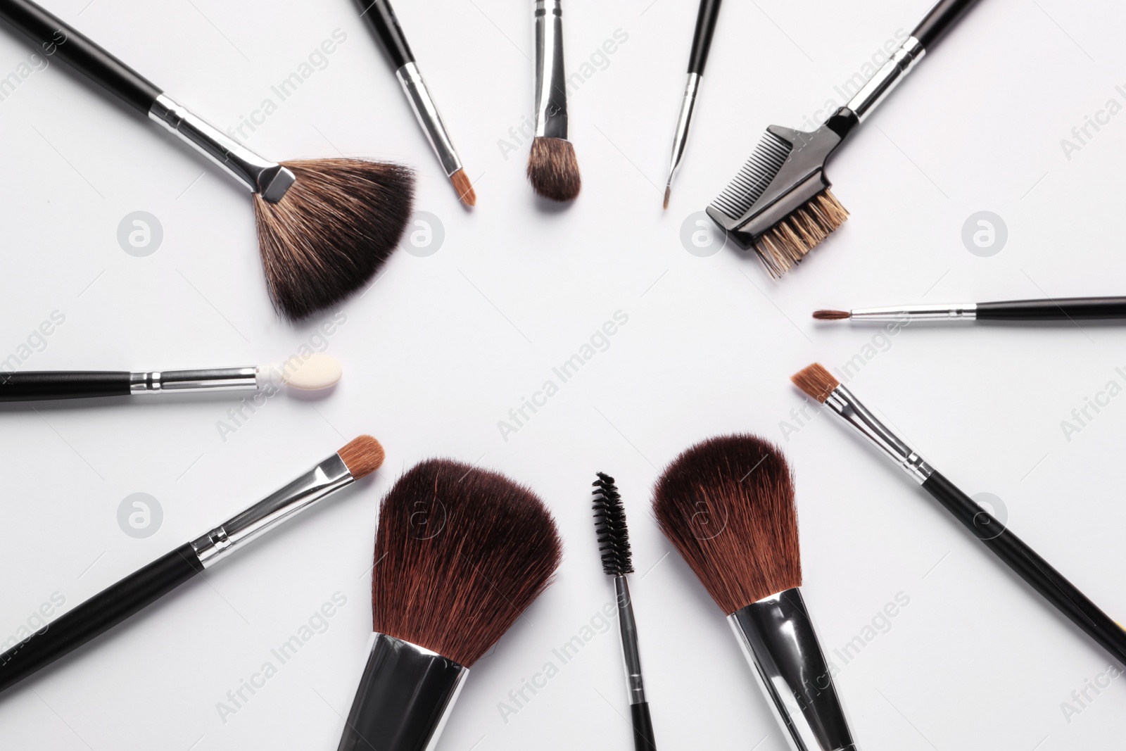 Photo of Frame of makeup brushes on white background, flat lay