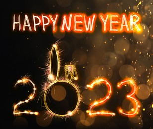 Image of Bright text Happy New 2023 Year made of firework on dark background. Greeting card design