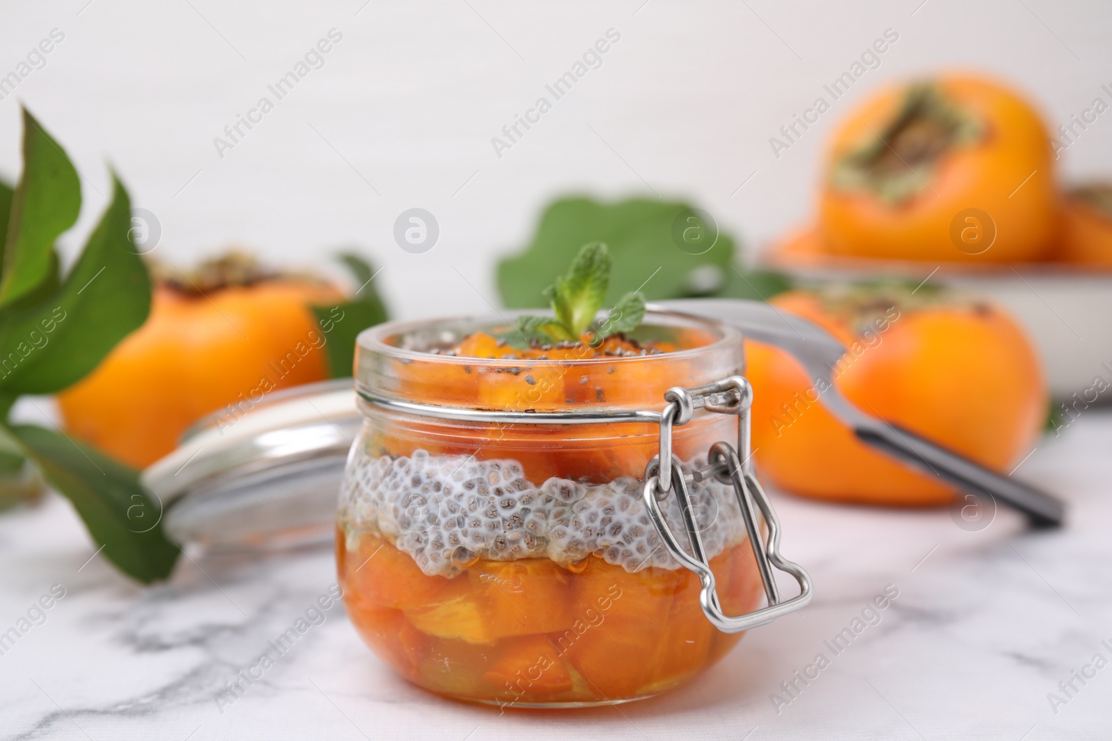 Photo of Delicious dessert with persimmon and chia seeds on table