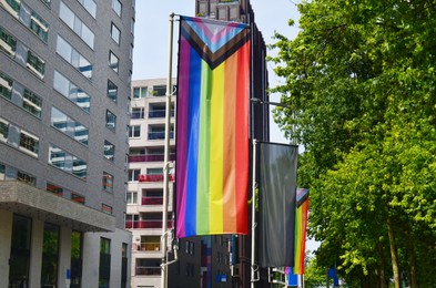 Photo of Rainbow flag on city street. Pride month