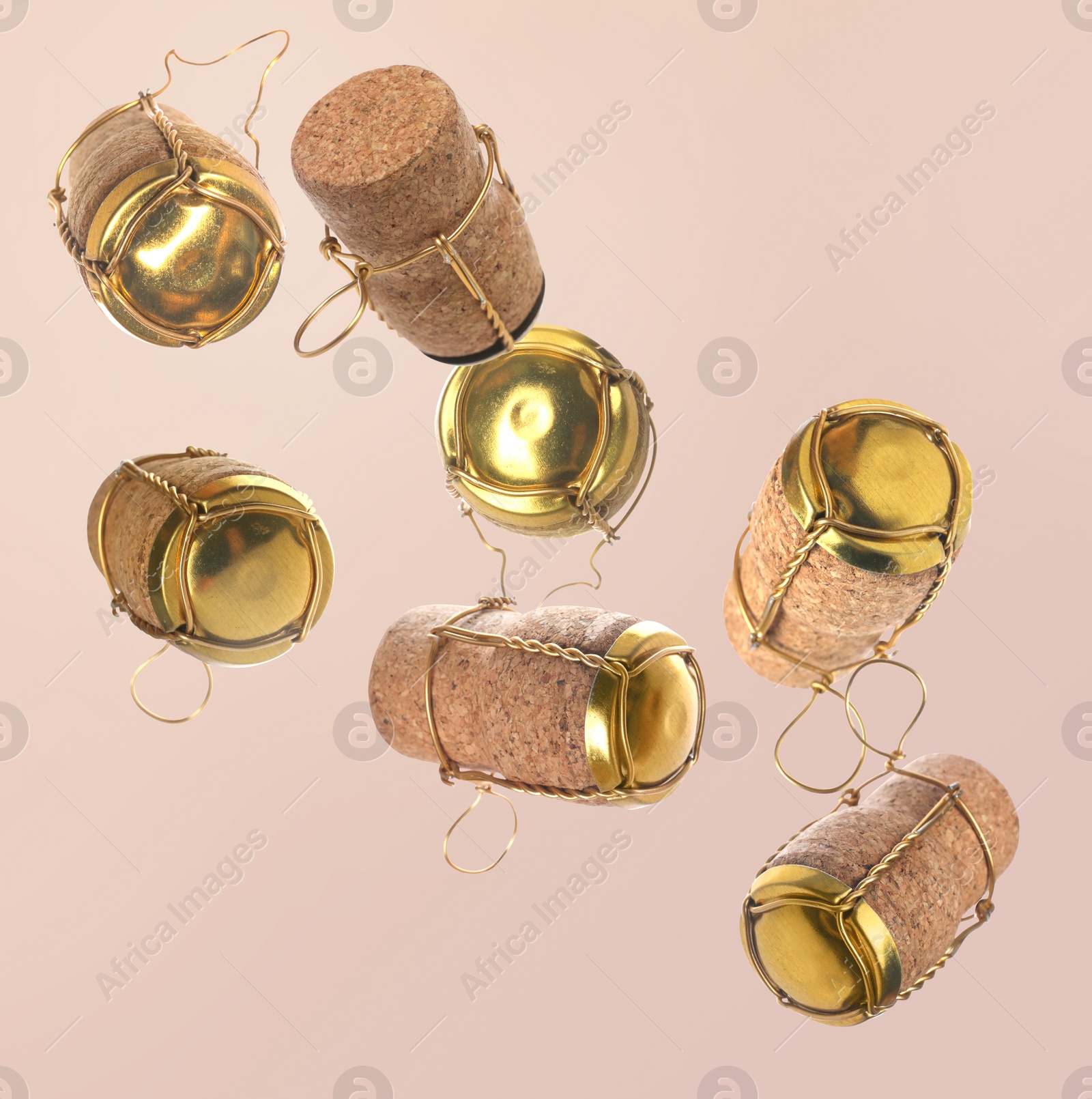 Image of Many corks of sparkling wine bottles falling on light background