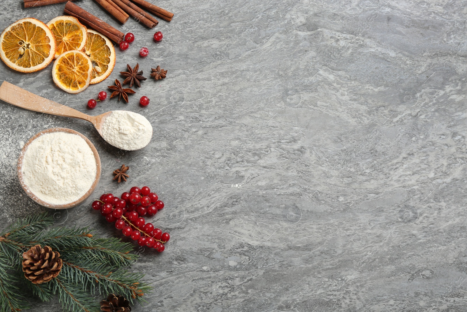 Photo of Flat lay composition with Christmas decor and flour on grey table. Space for text