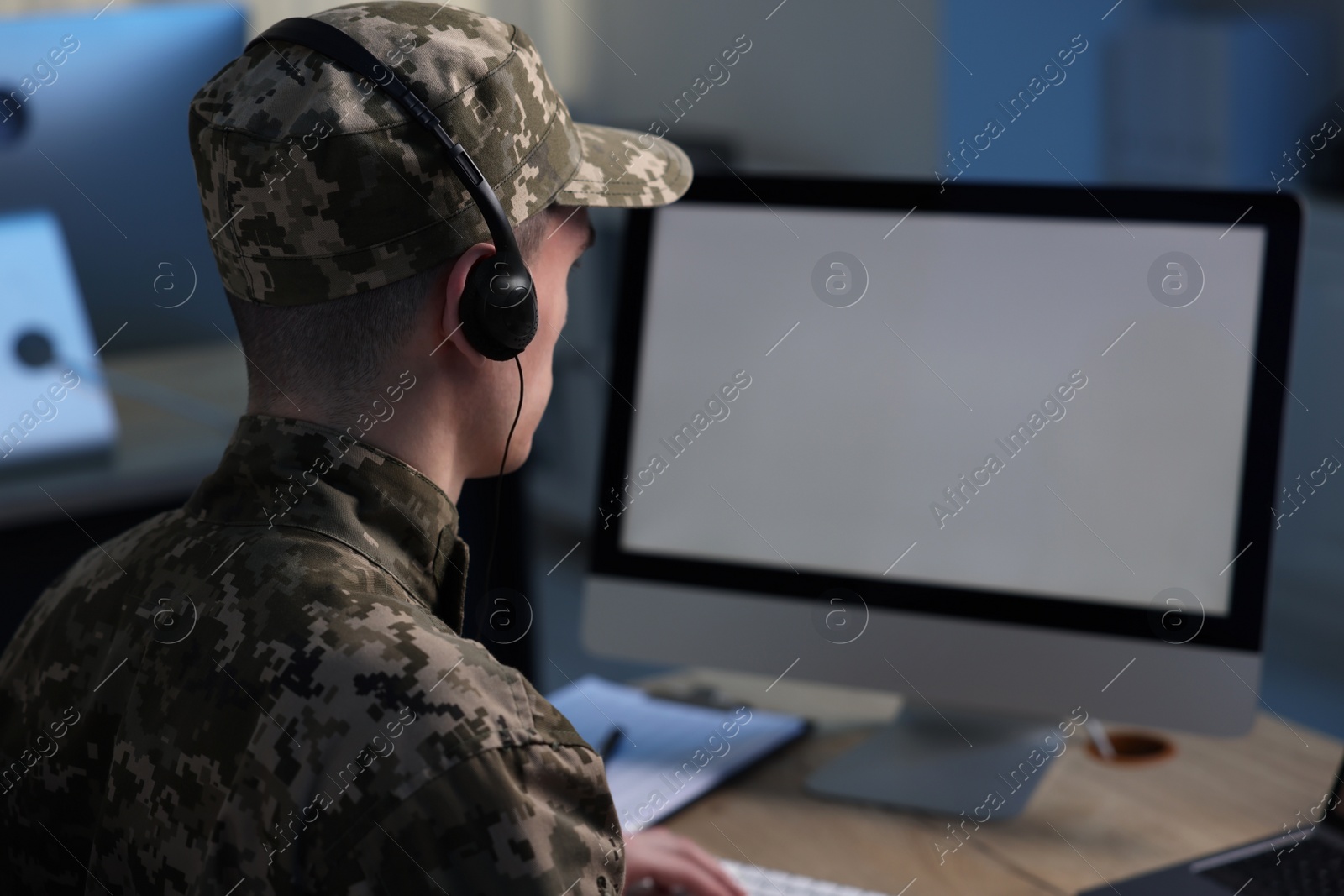 Photo of Military service. Soldier in headphones working in office, space for text