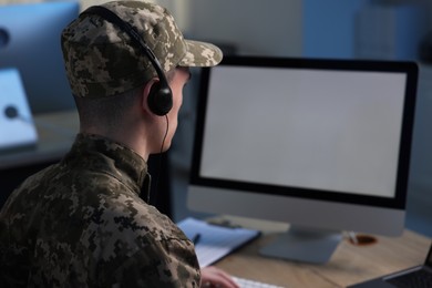 Photo of Military service. Soldier in headphones working in office, space for text