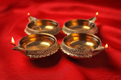 Photo of Diwali diyas or clay lamps on color fabric