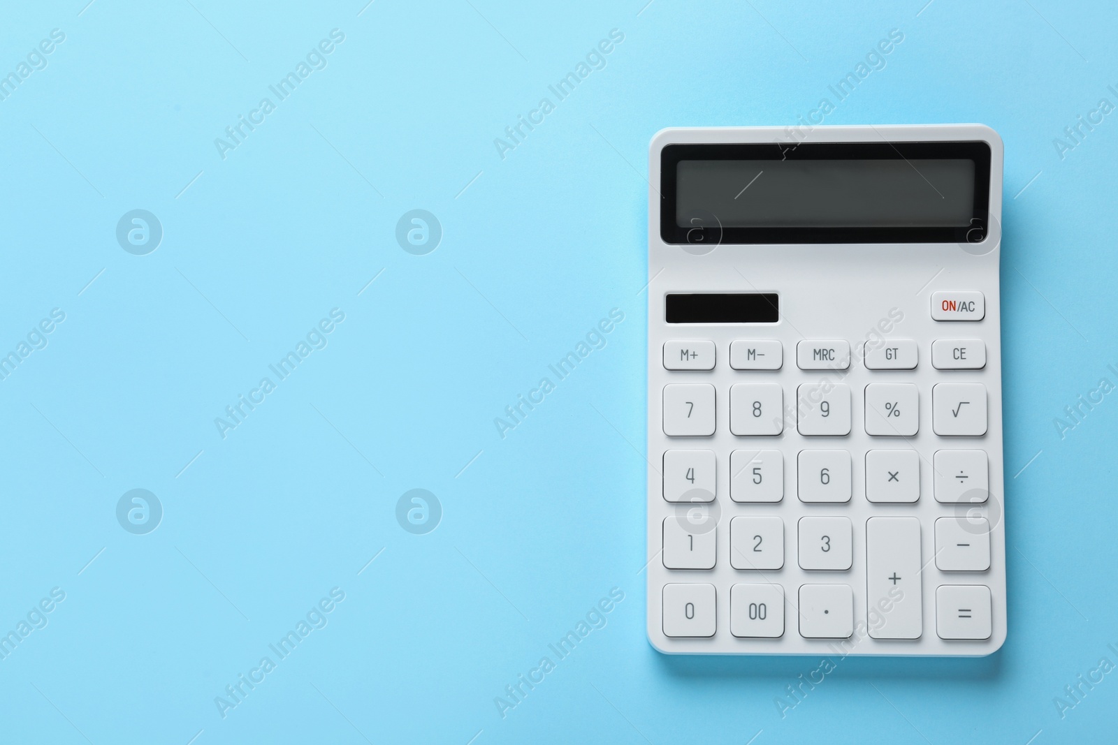 Photo of White calculator on light blue background, top view. Space for text