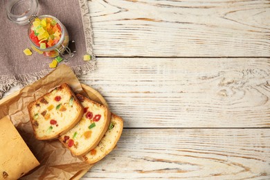 Delicious cake with candied fruits on white wooden table, flat lay. Space for text