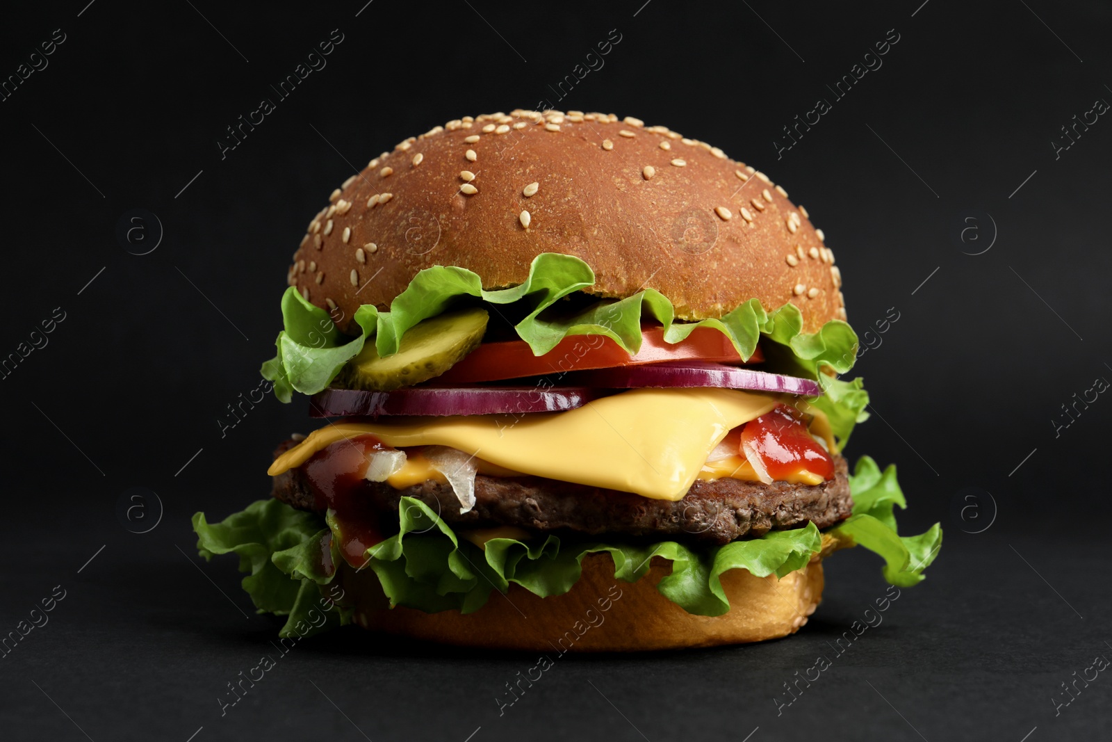 Photo of Delicious burger with beef patty and lettuce on black background