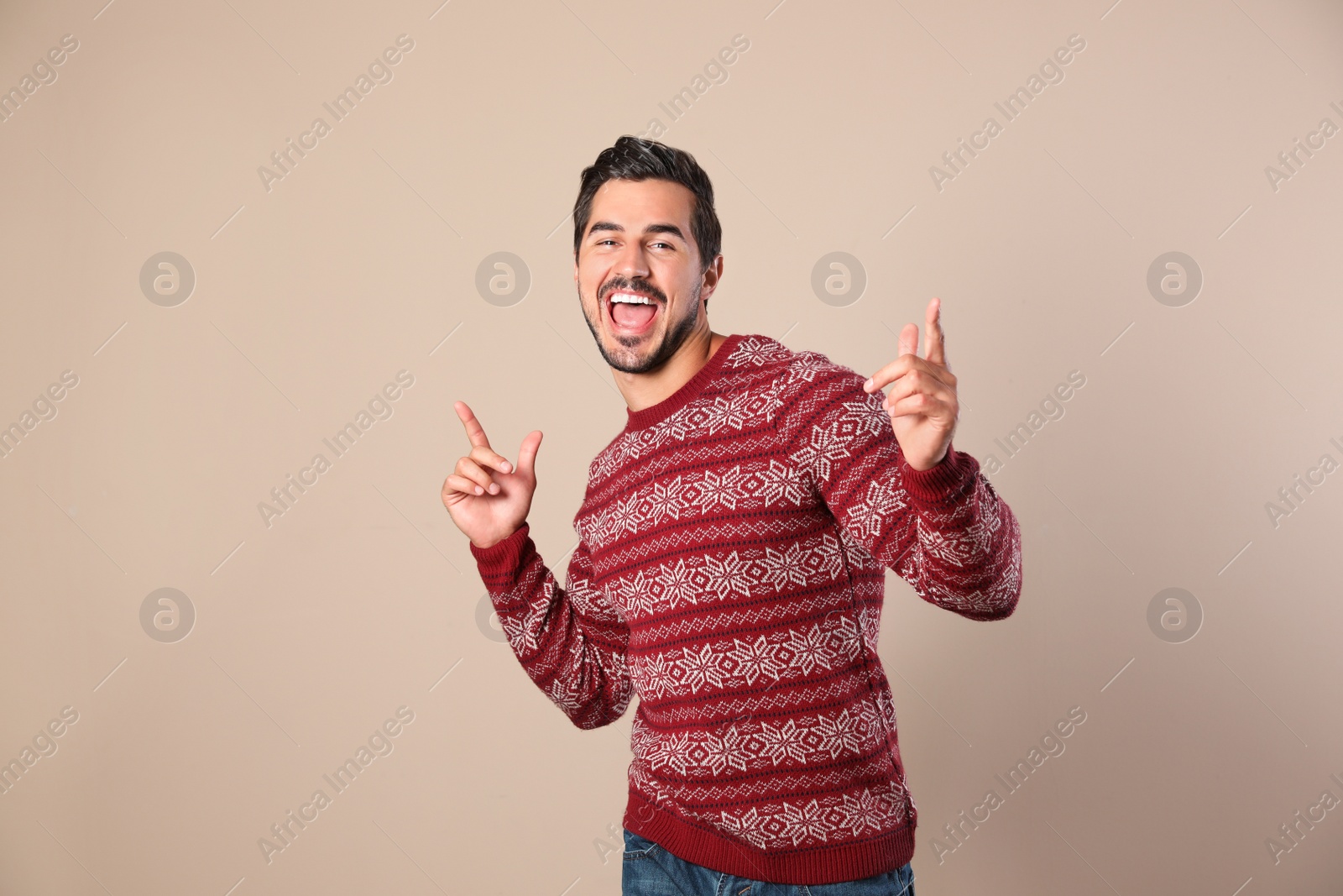 Photo of Portrait of happy man in Christmas sweater on beige background