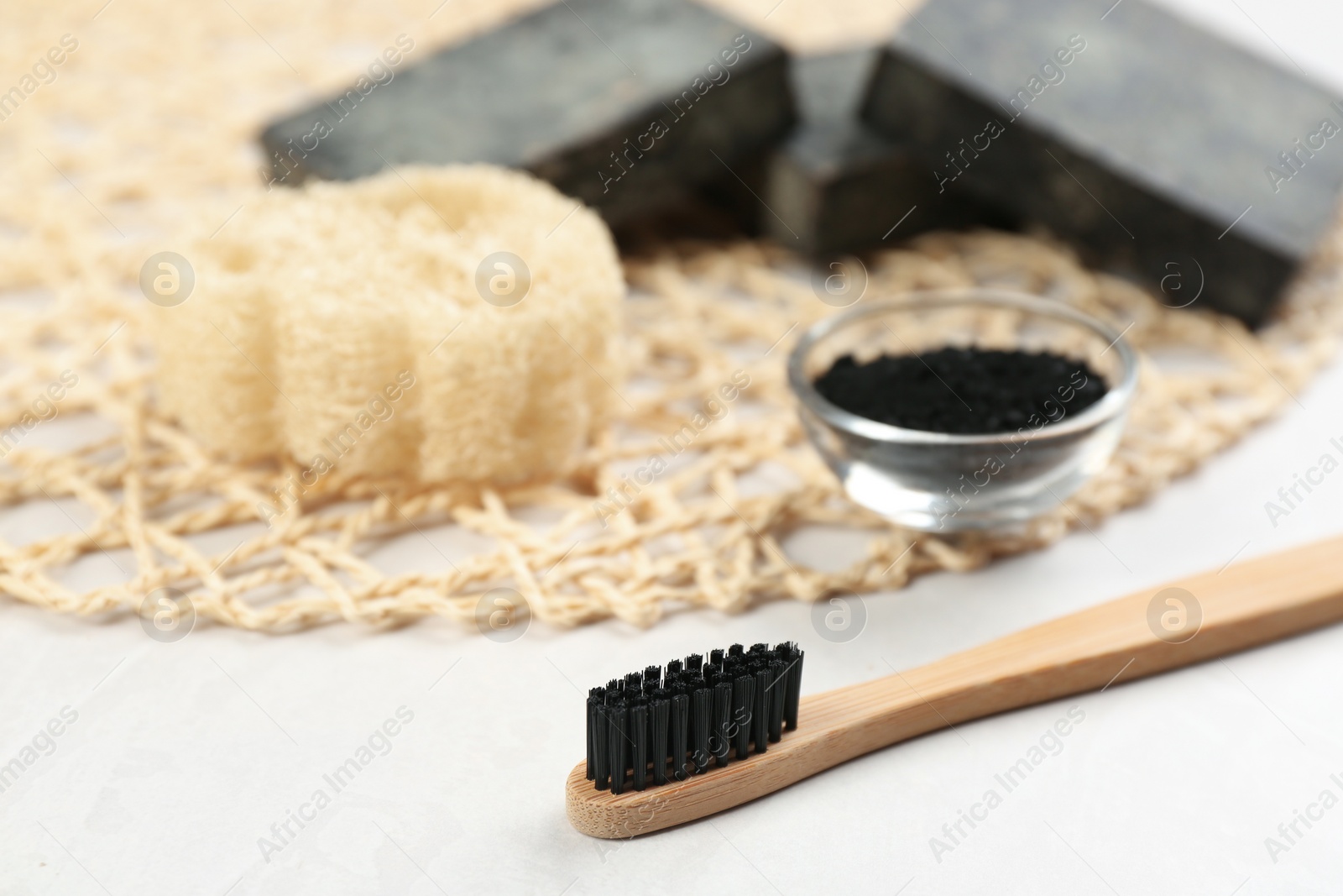 Photo of Bamboo toothbrush on white table, closeup. Space for text