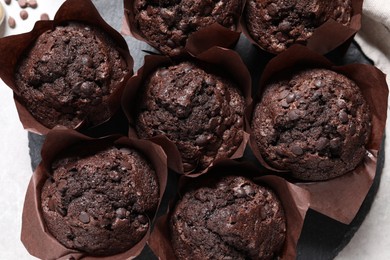 Photo of Tasty chocolate muffins on light table, top view