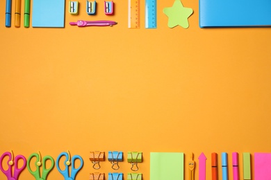 different school stationery on orange background, flat lay. Space for text