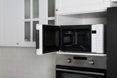 Photo of Modern oven and microwave in white clean kitchen