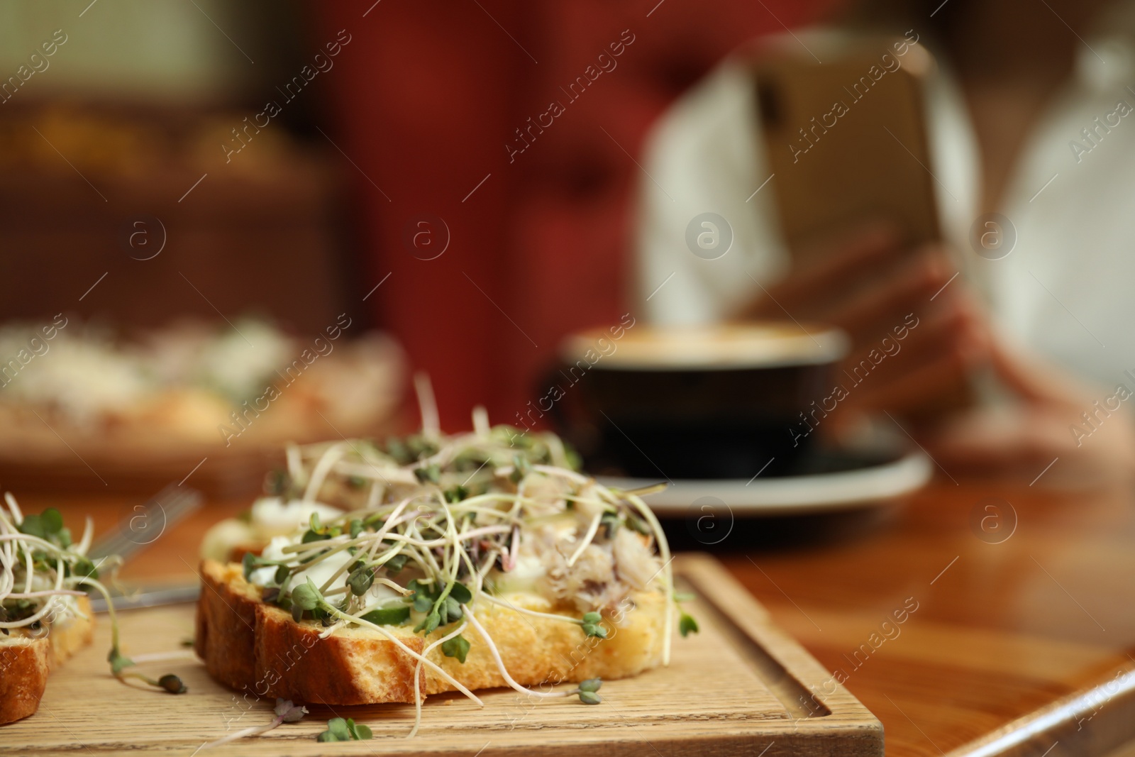 Photo of Food blogger taking photo of lunch in cafe, focus on delicious bruschettas