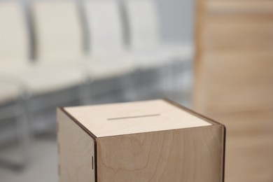 Photo of Wooden ballot box on blurred background, closeup. Space for text