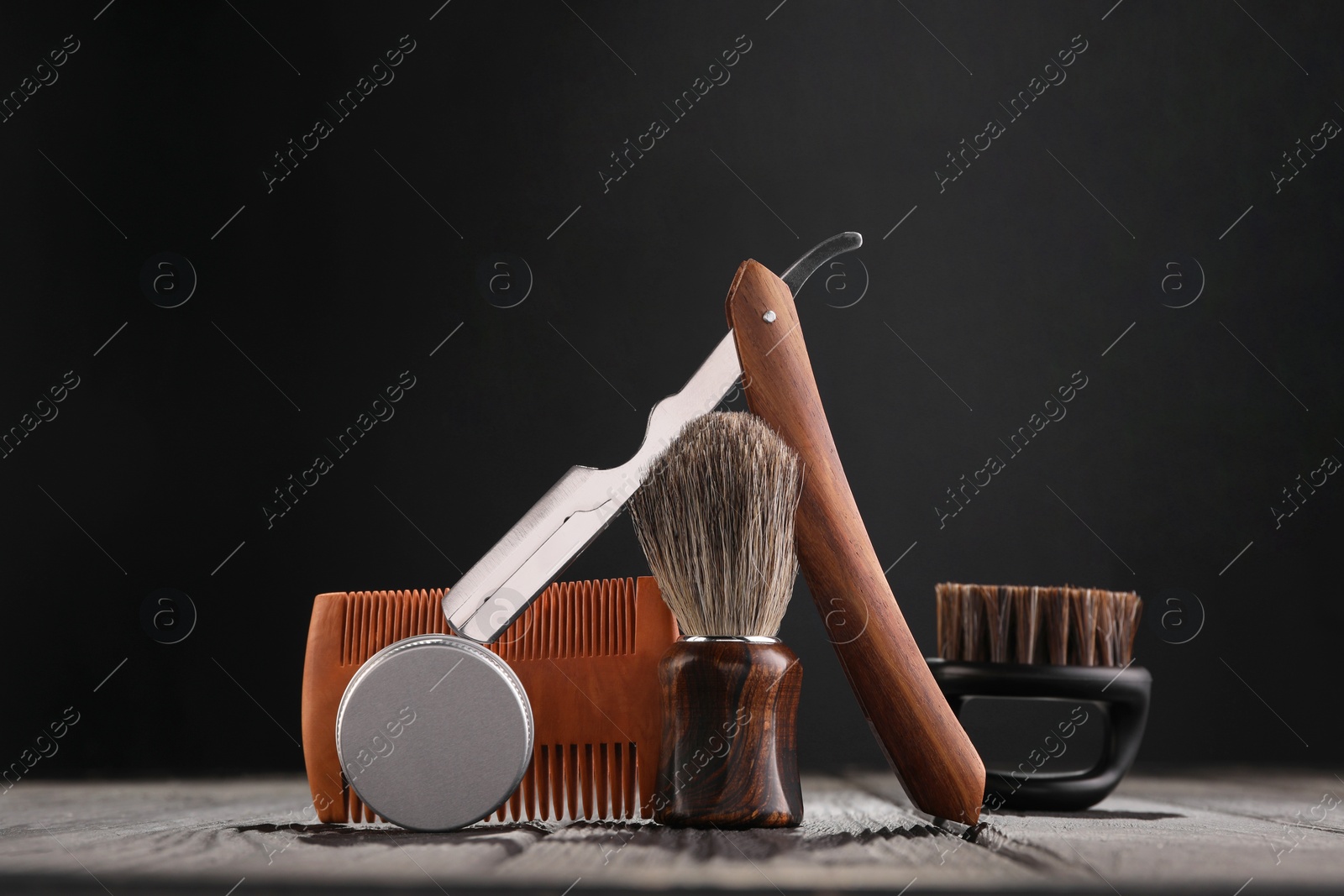 Photo of Moustache and beard styling tools on wooden table