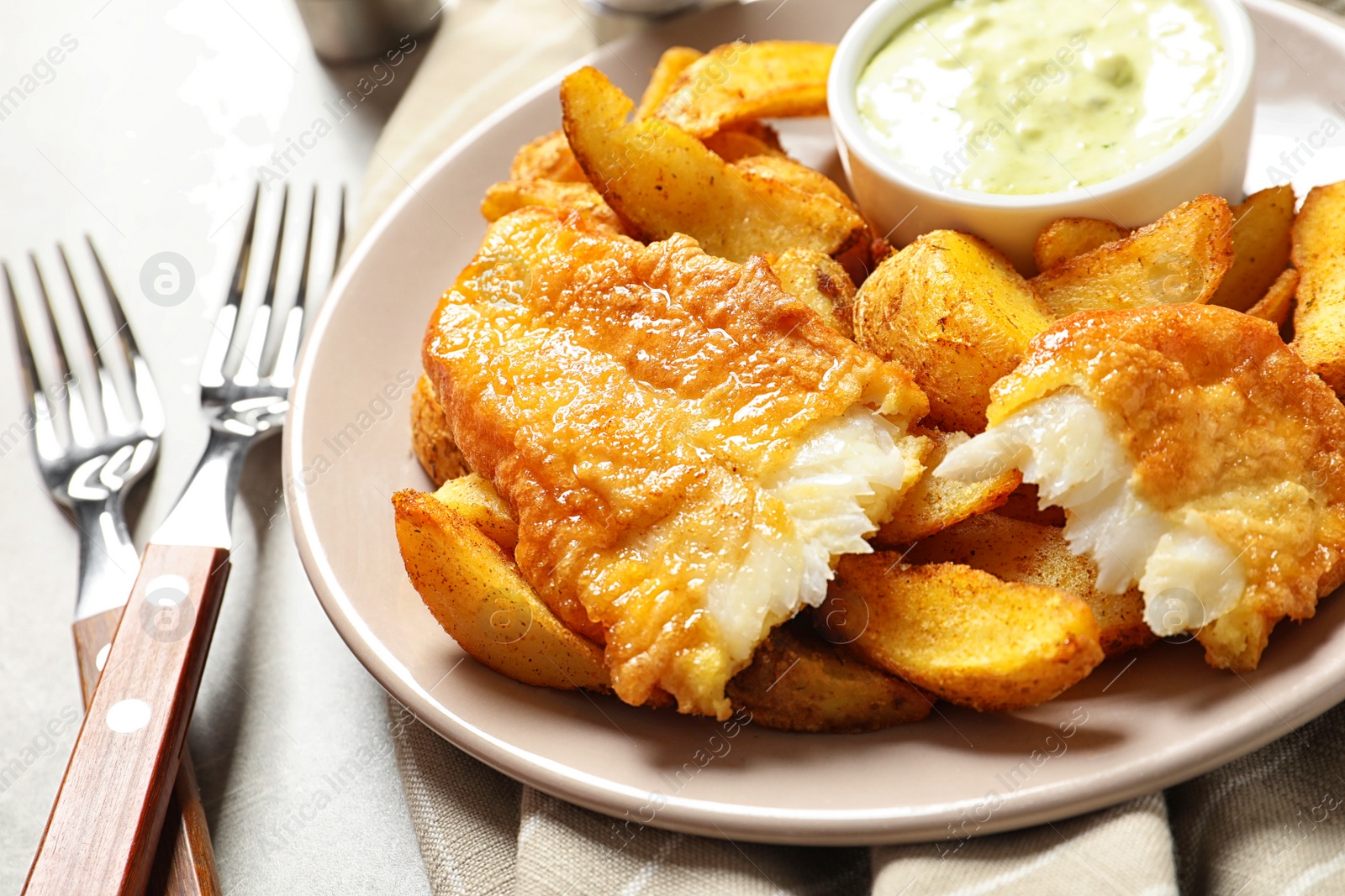 Photo of Plate with British Traditional Fish and potato chips on grey background, closeup