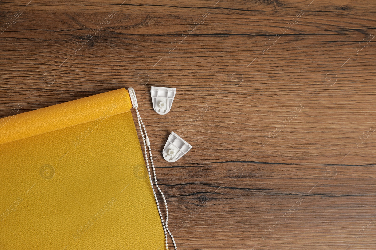 Photo of Stylish roller window blinds and details
on wooden table, flat lay. Space for text