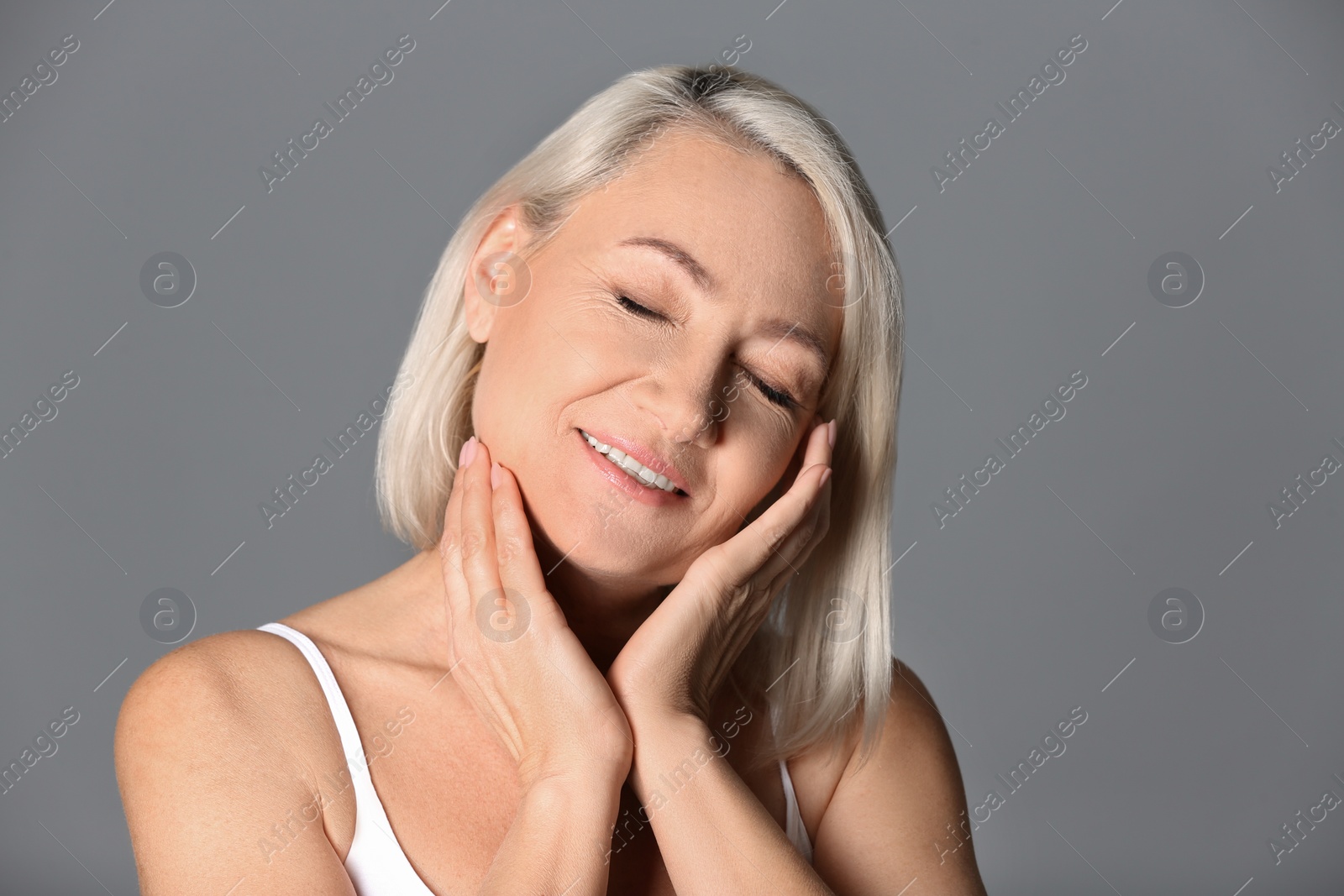 Photo of Portrait of beautiful mature woman on grey background