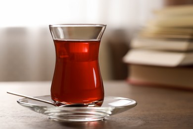 Photo of Glass of traditional Turkish tea on wooden table, closeup. Space for text