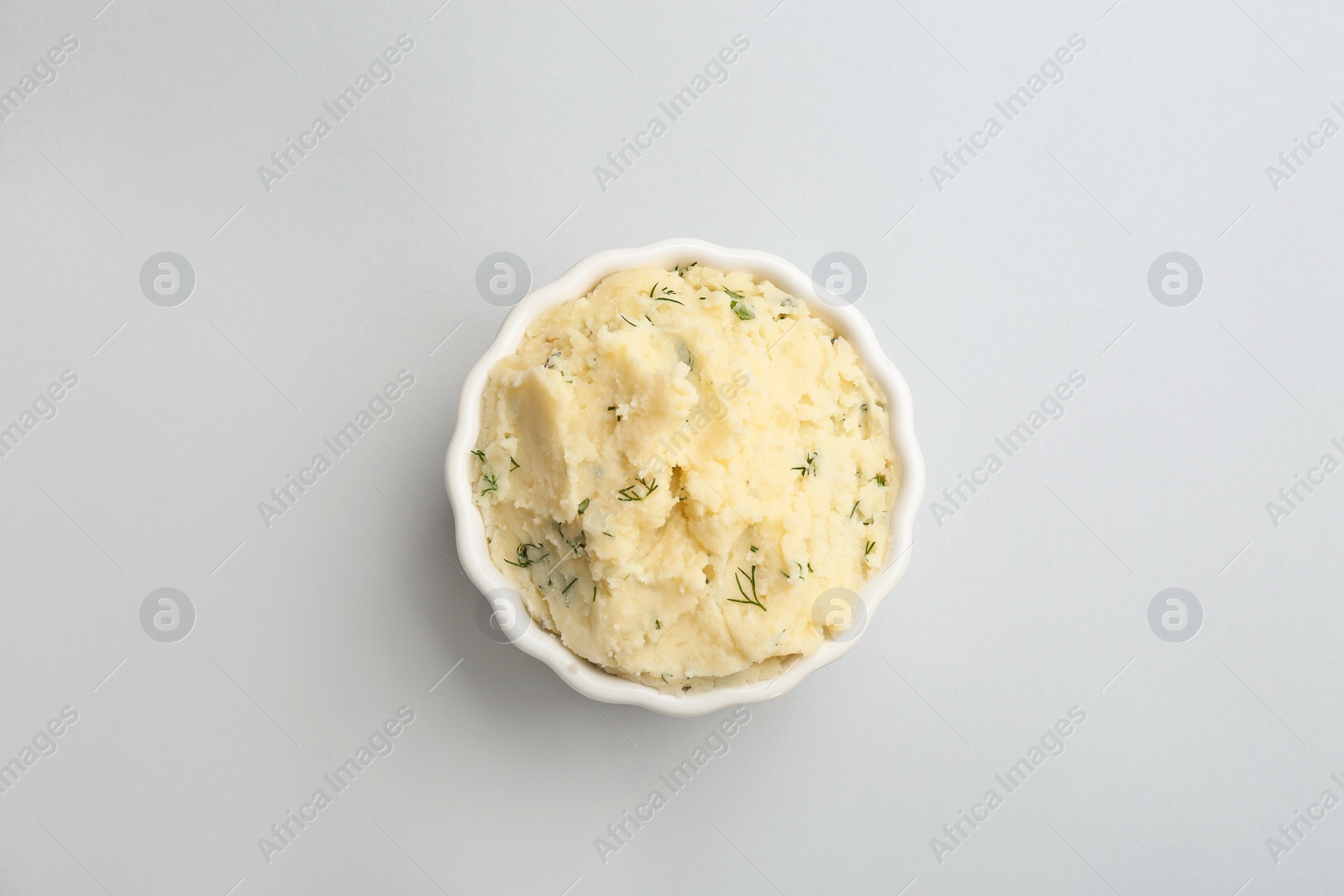 Photo of Bowl with tasty mashed potato on light background, top view