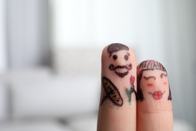 Photo of Two fingers with drawings of happy faces on blurred background, space for text. Spending time together