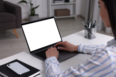 Photo of Woman working with laptop at white desk indoors, closeup