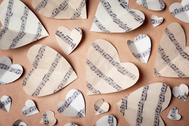 Paper hearts with music notes on color background, flat lay