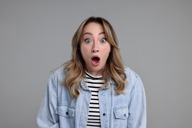 Photo of Portrait of surprised woman on grey background