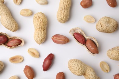 Fresh peanuts on white table, flat lay