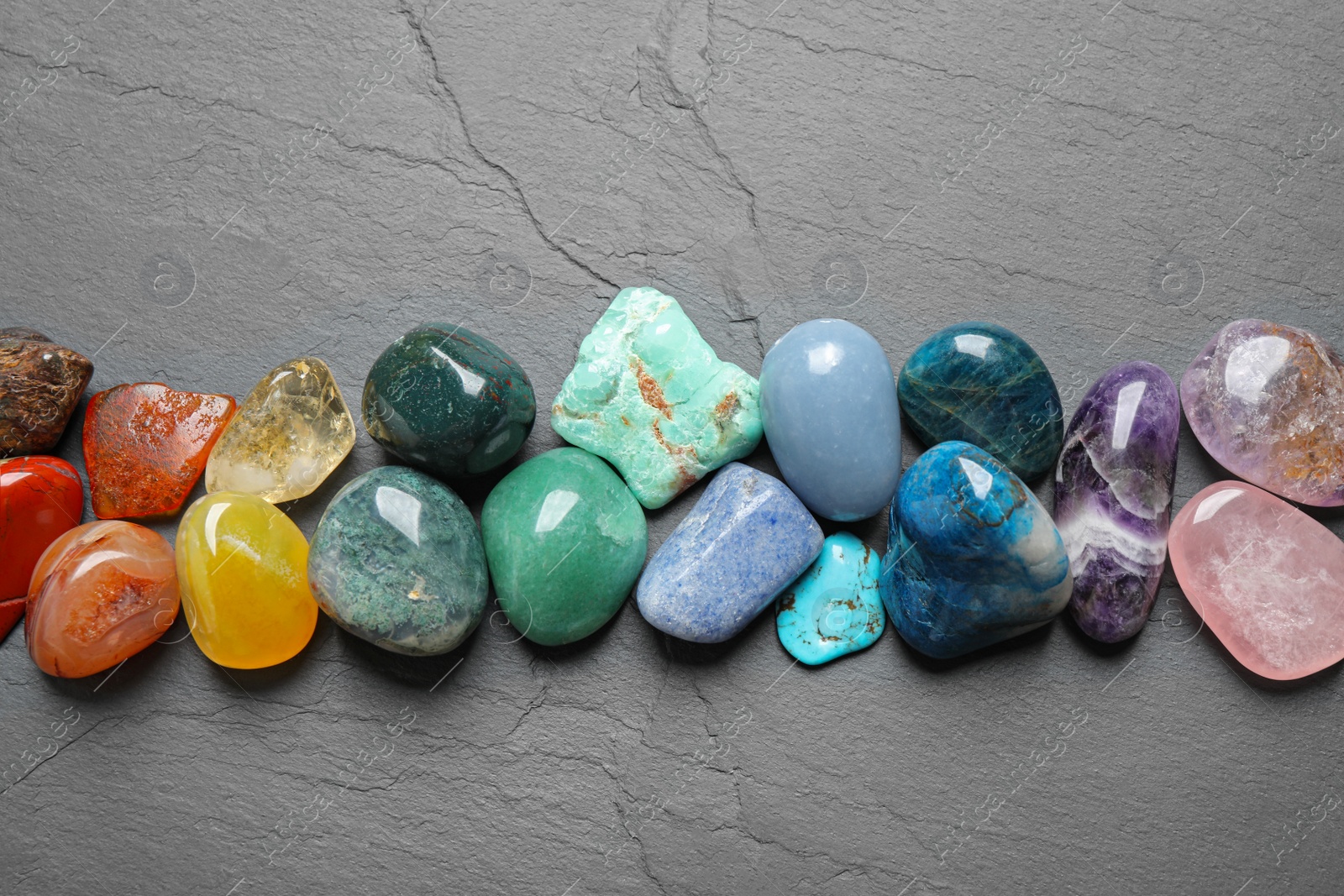 Photo of Flat lay composition with different gemstones on grey table