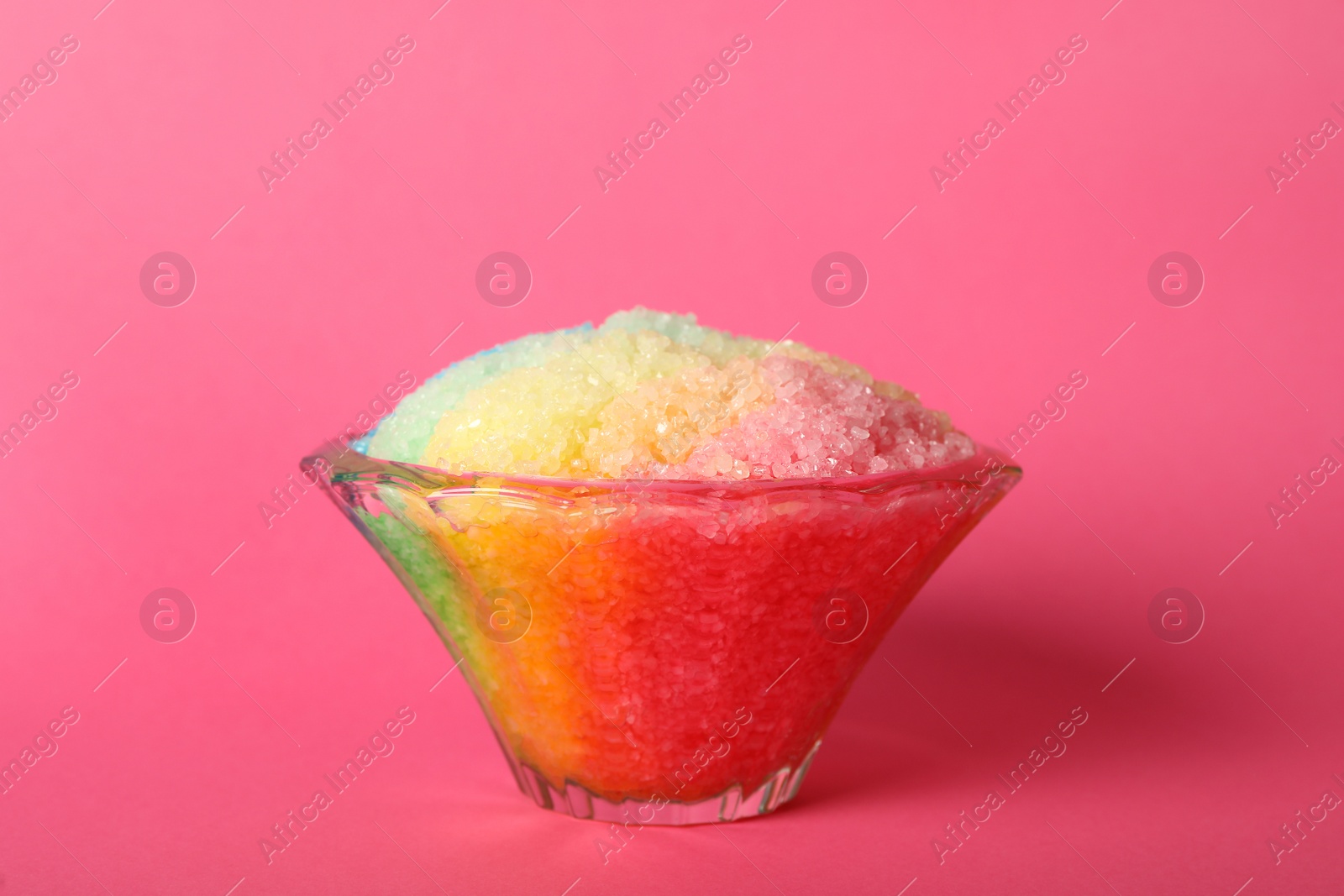 Photo of Rainbow shaving ice in glass dessert bowl on pink background