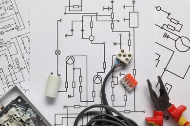 Wires, pliers and disassembled light switch on wiring diagrams, flat lay