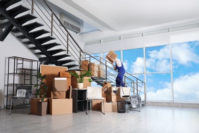 Photo of Man with box going up stairs near packed stuff in office