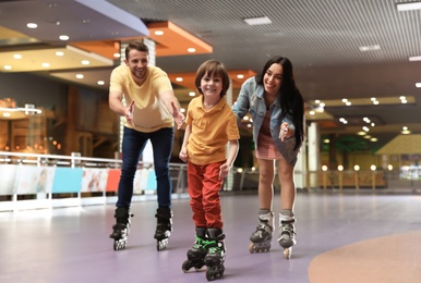 Happy family spending time at roller skating rink