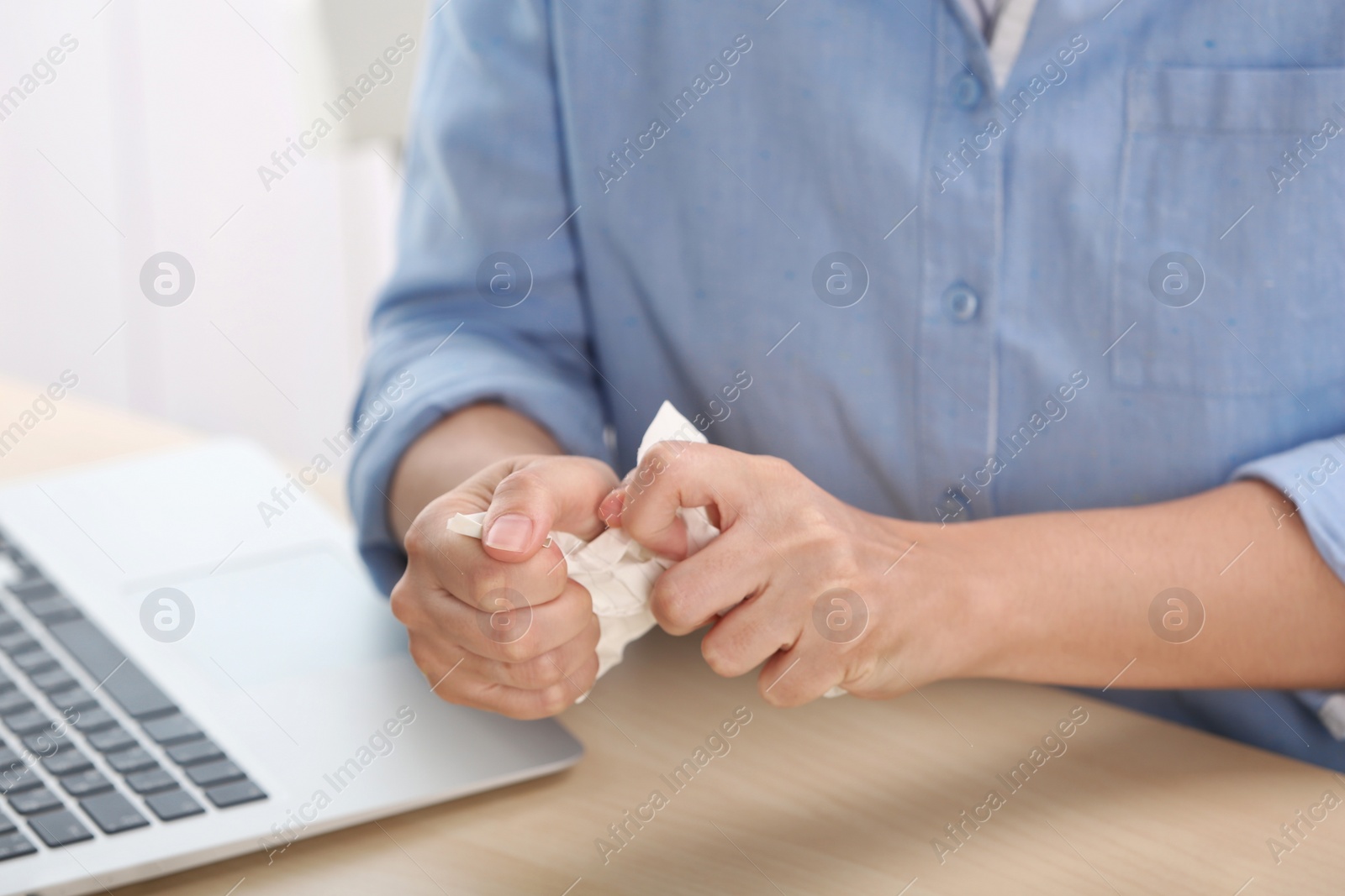 Photo of Woman crumpling paper at table, closeup. Generating idea