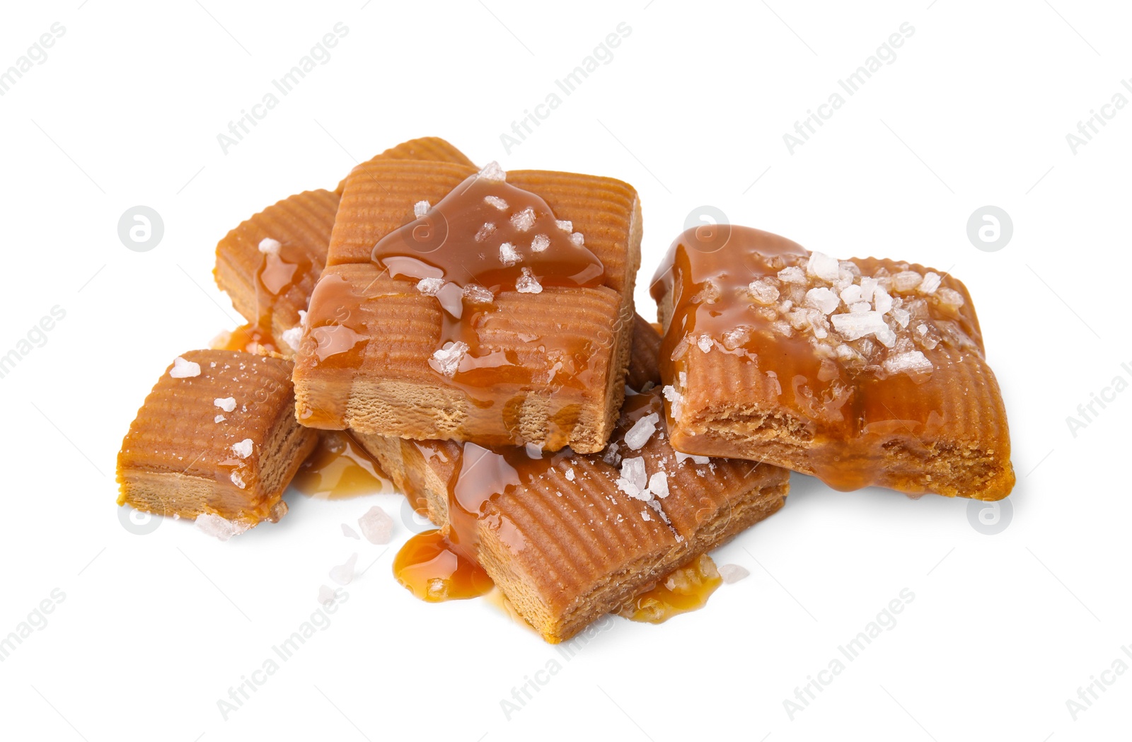 Photo of Yummy caramel candies and sea salt isolated on white