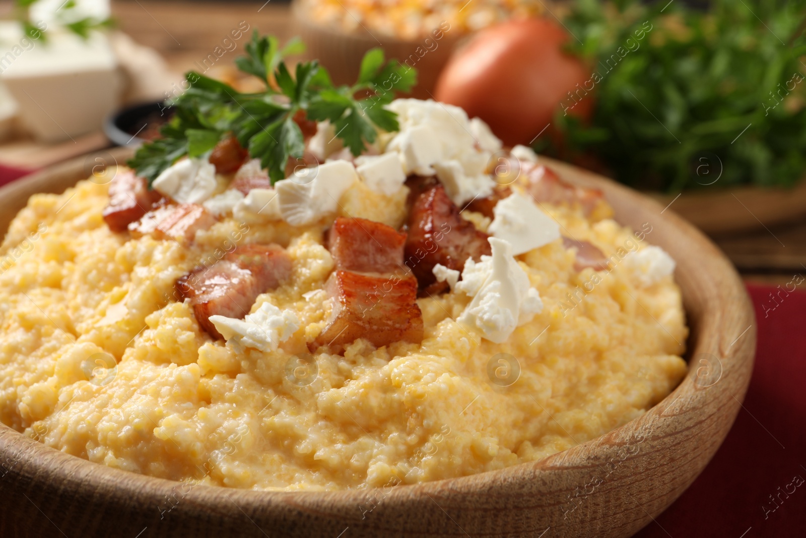 Photo of Delicious traditional Ukrainian banosh in wooden bowl on table, closeup