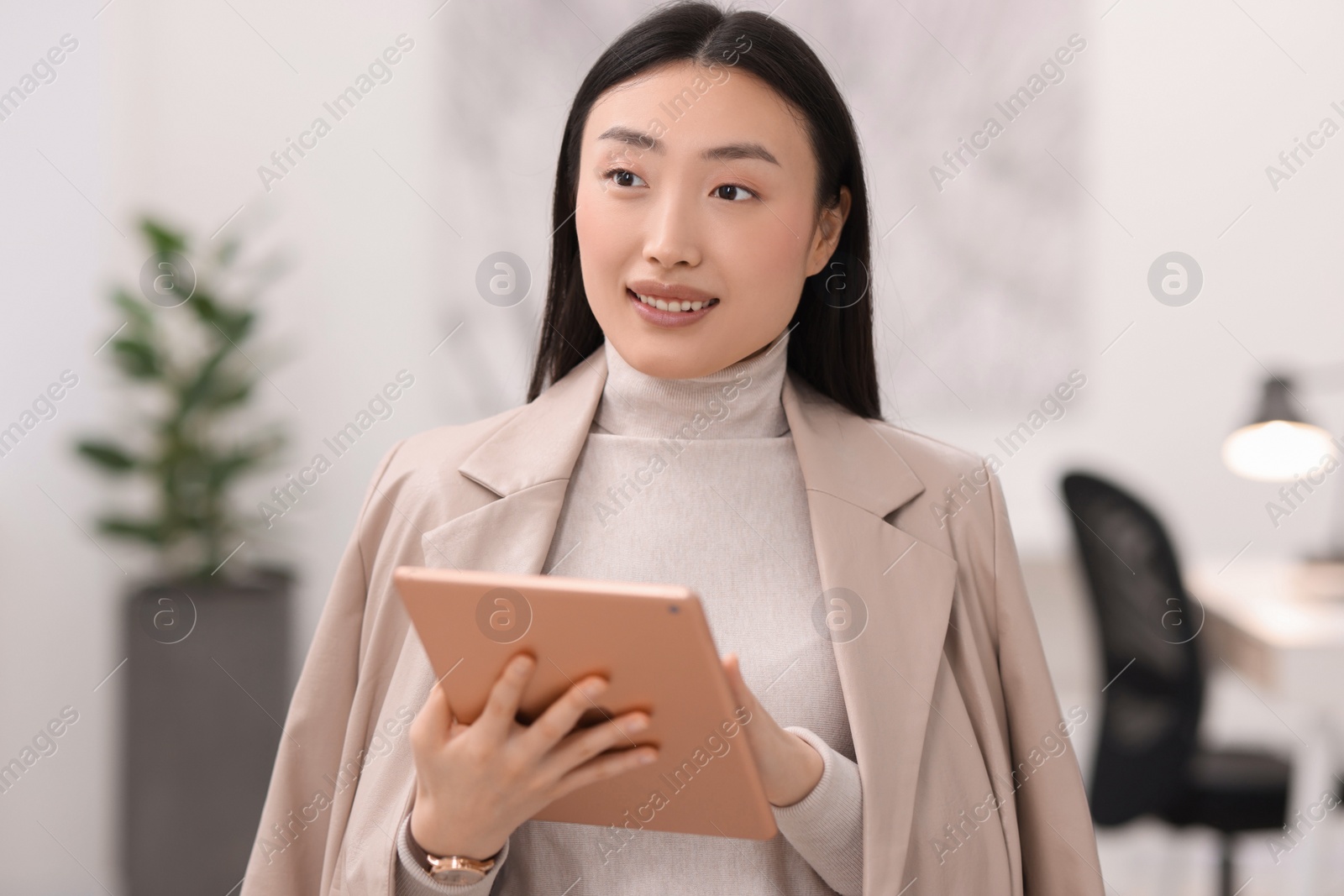 Photo of Portrait of smiling businesswoman with tablet in office