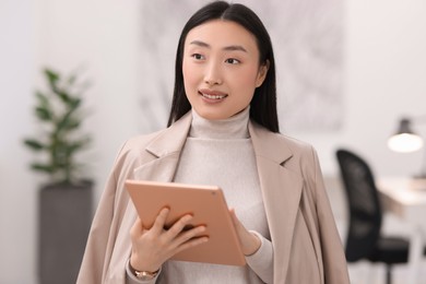 Portrait of smiling businesswoman with tablet in office