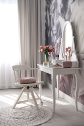 Stylish room interior with elegant dressing table and floral wallpaper