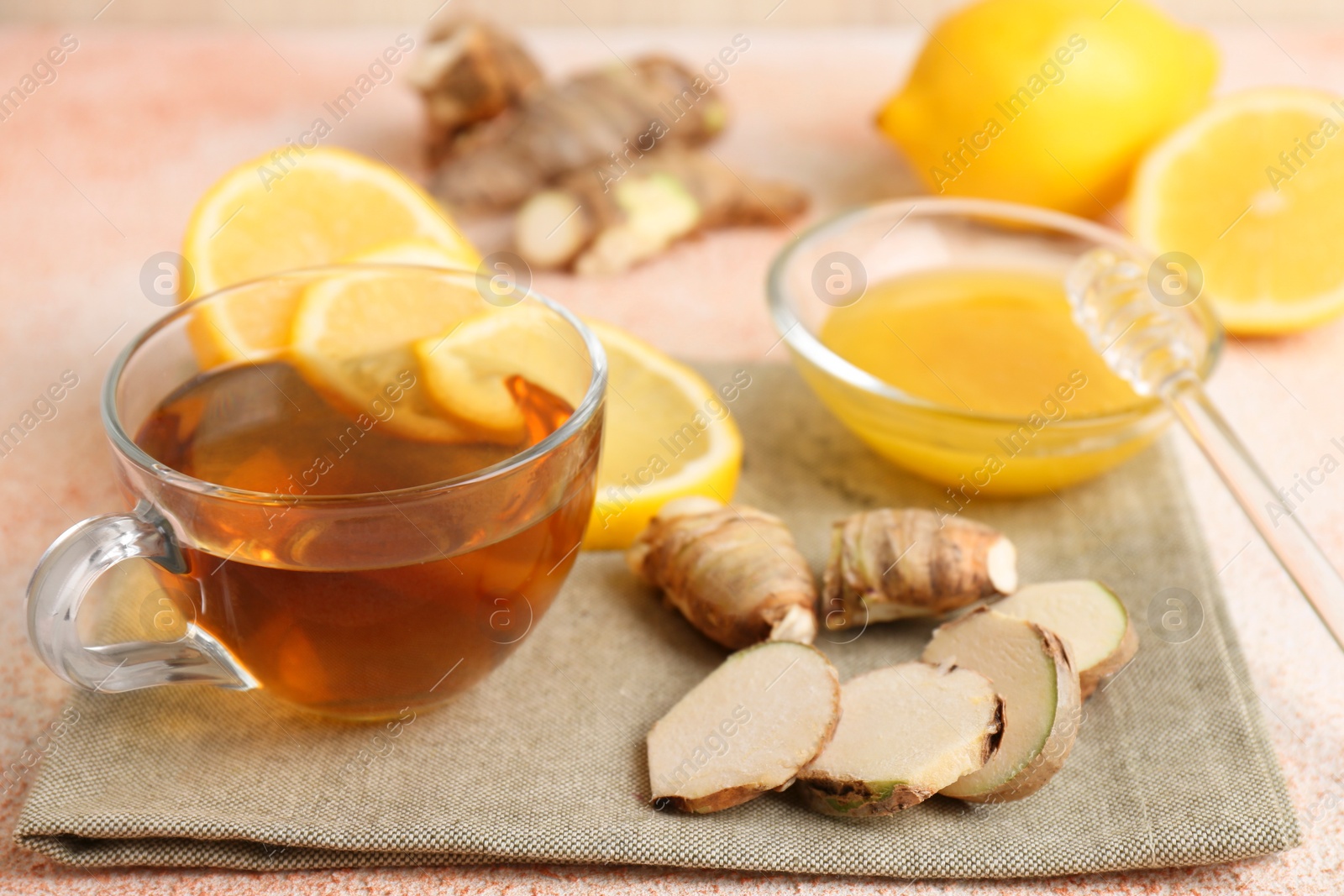 Photo of Tea, honey, lemon and ginger on table